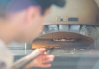 food truck worker using a pizza oven